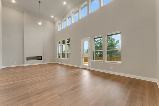 304 Alicia Ct, Mansfield, TX 76063 - unfurnished living room with light wood finished floors, a glass covered fireplace, and baseboards