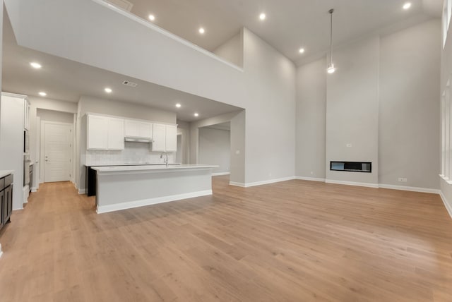 304 Alicia Ct, Mansfield, TX 76063 - unfurnished living room with recessed lighting, light wood-style flooring, a towering ceiling, a large fireplace, and baseboards
