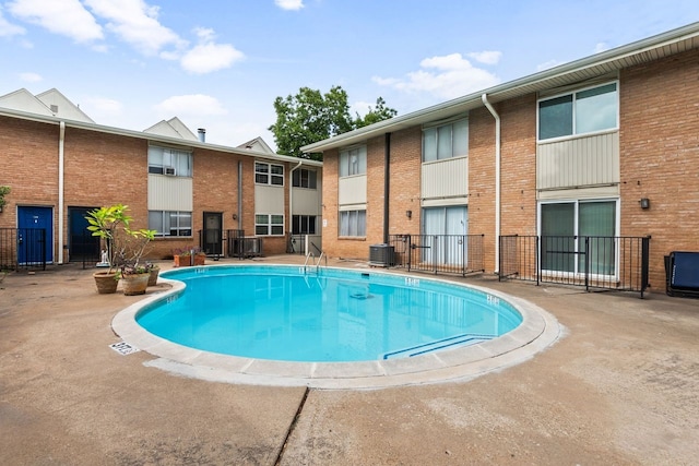 view of pool with a patio area and central air condition unit