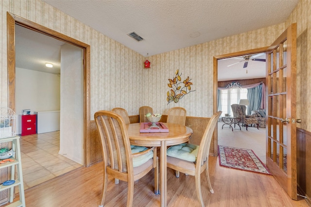 dining room featuring ceiling fan, hardwood / wood-style flooring, and a textured ceiling