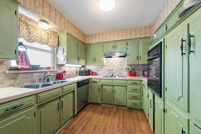 kitchen with sink, gas stovetop, green cabinetry, a textured ceiling, and stainless steel dishwasher