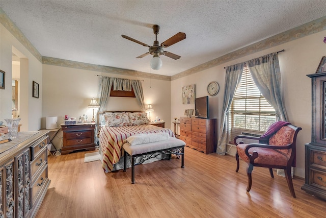 bedroom featuring a textured ceiling, light hardwood / wood-style floors, and ceiling fan