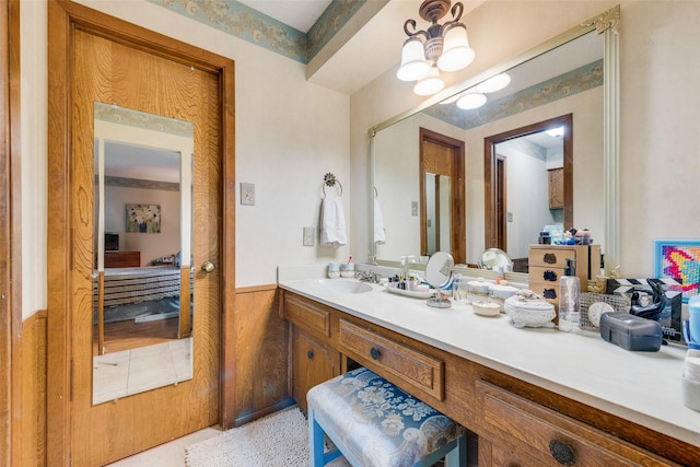 bathroom featuring vanity, a notable chandelier, and wood walls