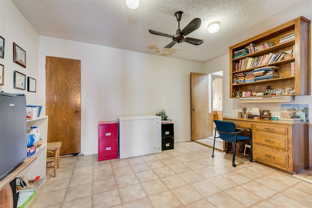 home office with a textured ceiling, built in desk, and ceiling fan