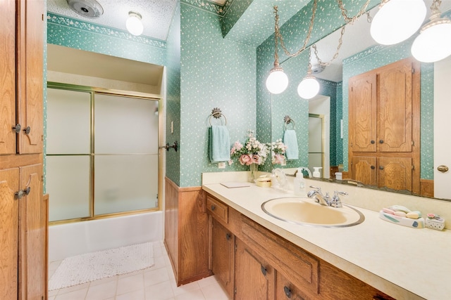 bathroom with tile patterned flooring, vanity, and shower / bath combination with glass door