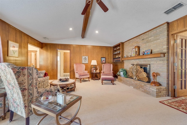 carpeted living room with a fireplace, lofted ceiling with beams, a textured ceiling, and wood walls