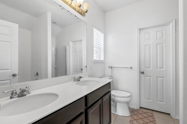 bathroom with tile patterned floors, toilet, a shower with shower door, and vanity