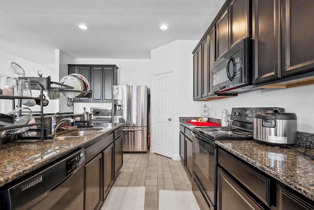 kitchen with dark stone countertops, sink, a textured ceiling, and black appliances