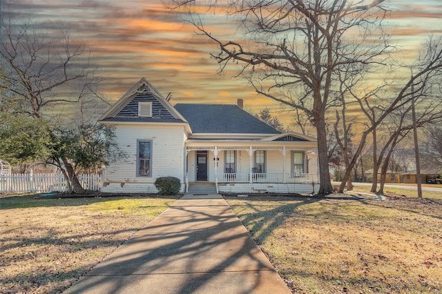 view of front facade featuring covered porch and a lawn