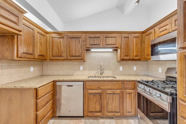 kitchen featuring stainless steel appliances, lofted ceiling, sink, and backsplash