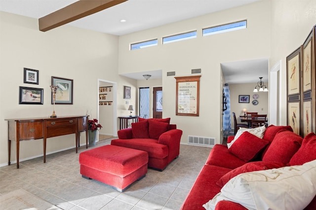 living room featuring a high ceiling, light tile patterned flooring, a notable chandelier, and beam ceiling