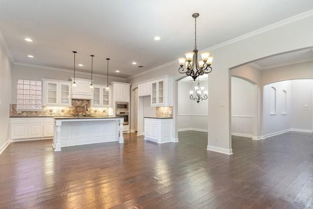 kitchen featuring white cabinetry, appliances with stainless steel finishes, a kitchen island, and decorative backsplash