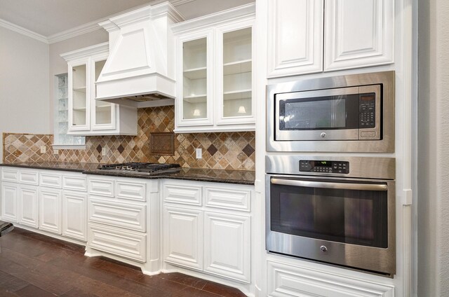 kitchen featuring sink, custom exhaust hood, decorative light fixtures, stainless steel appliances, and a kitchen island with sink