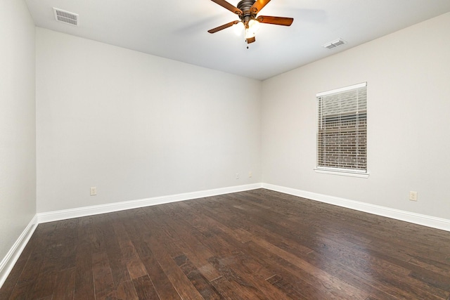 unfurnished room with dark wood-style floors, baseboards, visible vents, and a ceiling fan