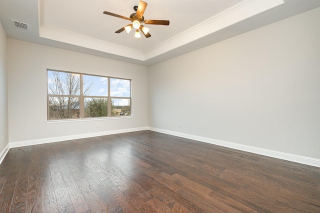 unfurnished room with baseboards, visible vents, a raised ceiling, and dark wood-style flooring