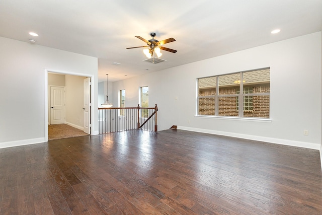 unfurnished room featuring recessed lighting, visible vents, dark wood finished floors, and baseboards