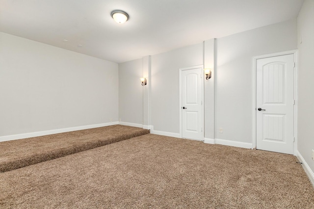 spare room featuring carpet and baseboards