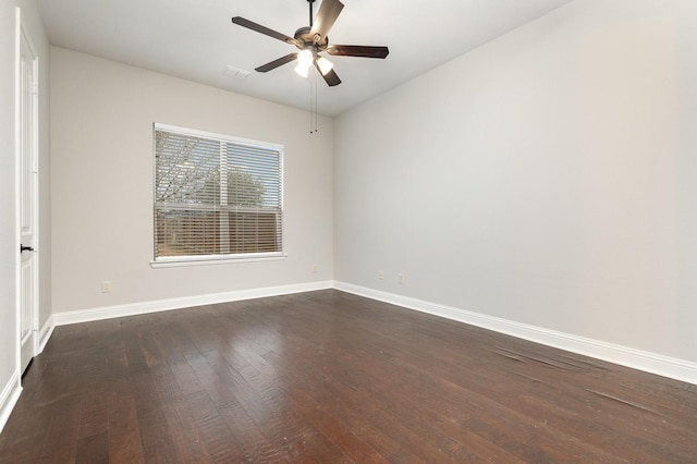 spare room with dark wood-style floors, baseboards, and a ceiling fan