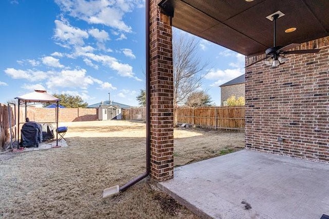 view of patio featuring a storage shed, a gazebo, and ceiling fan