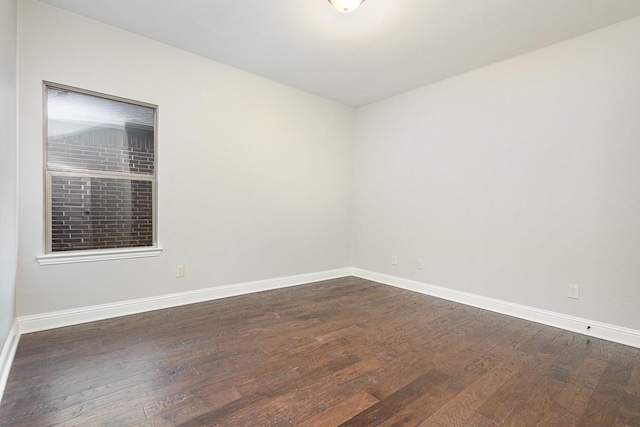 empty room with dark wood-style floors and baseboards