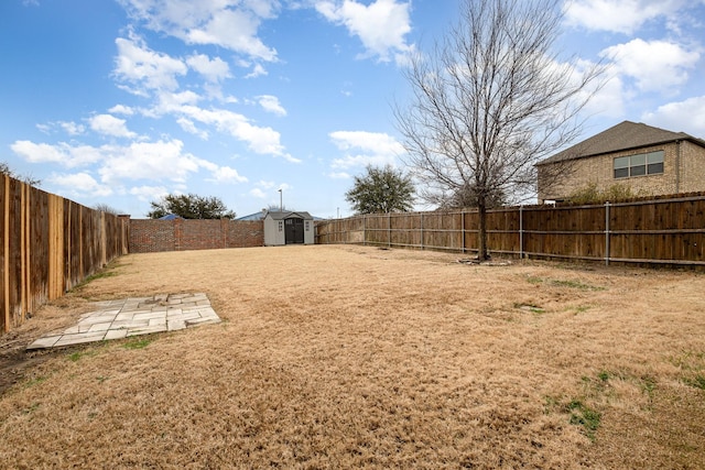 view of yard with an outbuilding, a fenced backyard, and a shed