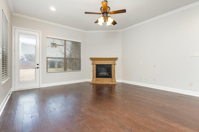 unfurnished living room featuring crown molding, a glass covered fireplace, dark wood finished floors, and baseboards