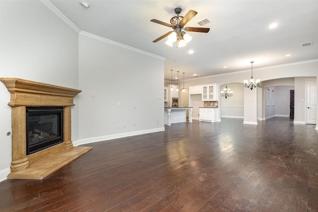 unfurnished living room featuring visible vents, dark wood finished floors, baseboards, a glass covered fireplace, and ceiling fan with notable chandelier