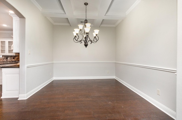 unfurnished dining area featuring baseboards, coffered ceiling, dark wood-type flooring, a chandelier, and beam ceiling