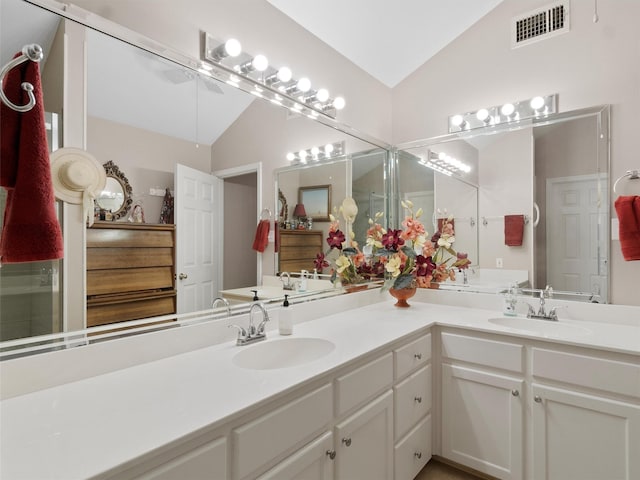 bathroom with lofted ceiling and vanity