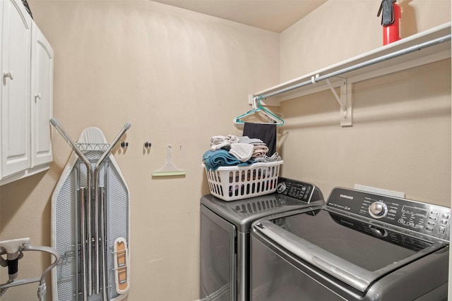 laundry area featuring cabinets and washing machine and clothes dryer