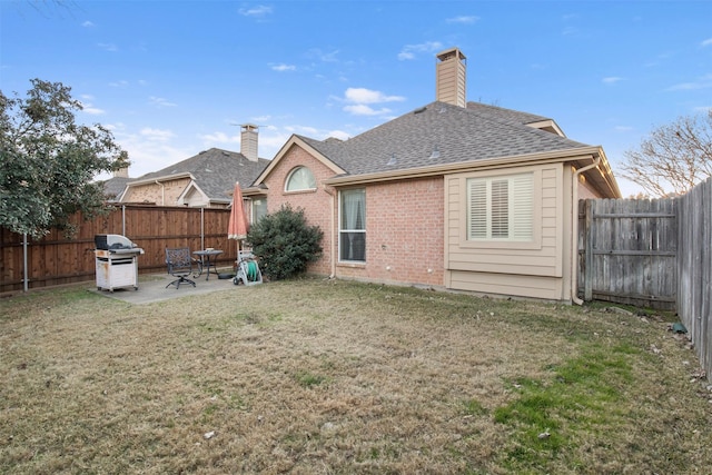 back of property with a yard and a patio