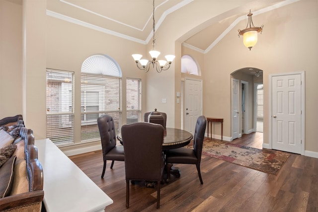 dining room featuring hardwood / wood-style flooring, ornamental molding, a notable chandelier, and high vaulted ceiling