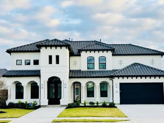 mediterranean / spanish house with a garage and a front yard