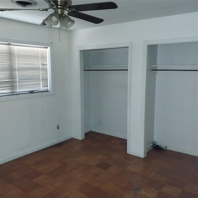 unfurnished bedroom with dark parquet flooring and ceiling fan