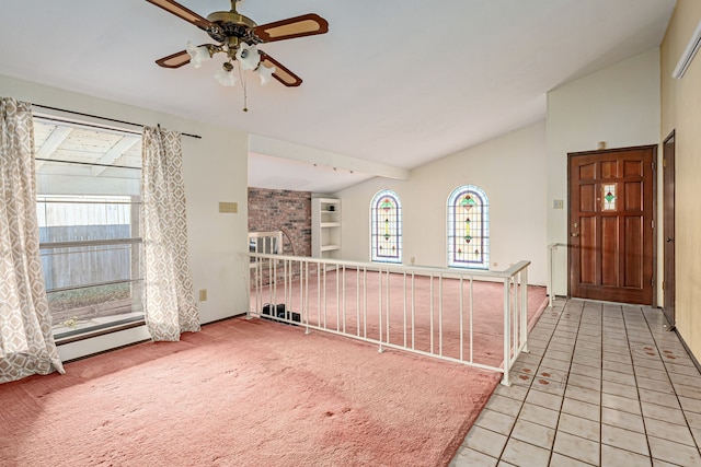 interior space featuring ceiling fan, tile patterned floors, and lofted ceiling