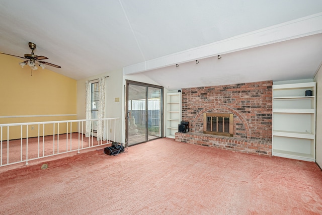 unfurnished living room with lofted ceiling with beams, ceiling fan, carpet floors, and a fireplace