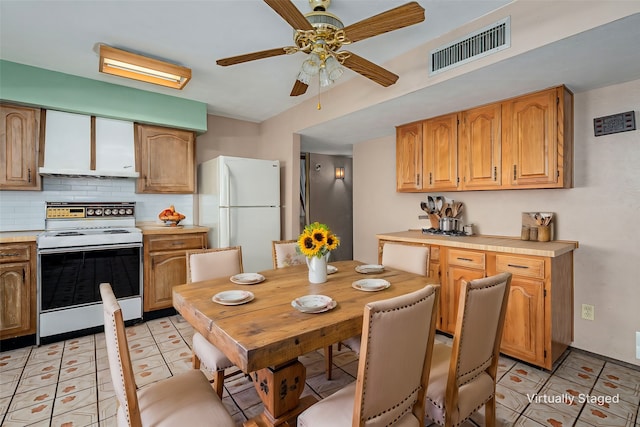 kitchen featuring tasteful backsplash, visible vents, ceiling fan, light countertops, and white appliances