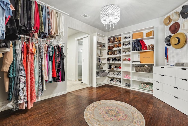 walk in closet with hardwood / wood-style floors and a notable chandelier