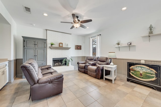 living room with a brick fireplace and ceiling fan