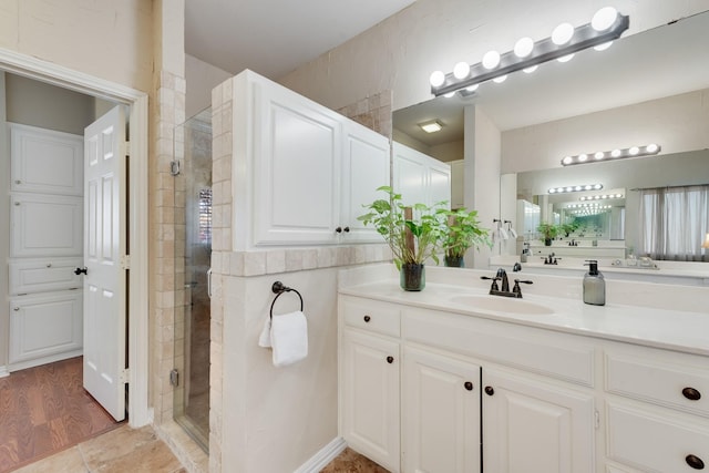 bathroom with a shower with door and vanity