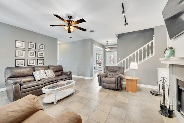 living room with track lighting, ceiling fan, and light tile patterned floors