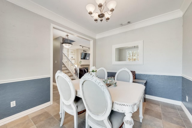 dining space featuring ornamental molding, a fireplace, and a chandelier