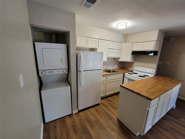 kitchen featuring butcher block countertops, white appliances, stacked washing maching and dryer, a textured ceiling, and white cabinets