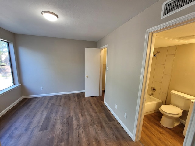 interior space featuring ensuite bath and dark hardwood / wood-style floors