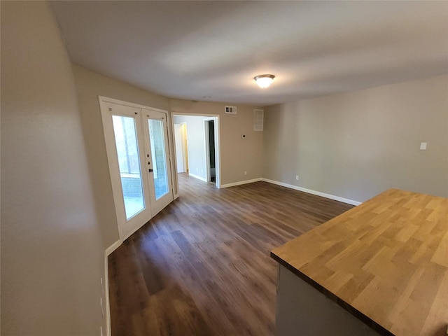 unfurnished room with dark hardwood / wood-style flooring and french doors