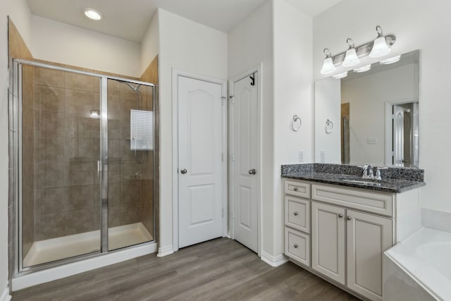 bathroom with shower with separate bathtub, wood-type flooring, and vanity