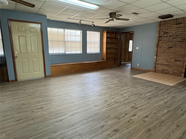 interior space with ceiling fan, hardwood / wood-style floors, and a drop ceiling