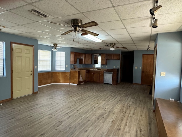 kitchen featuring a paneled ceiling, wood walls, dishwasher, ceiling fan, and light wood-type flooring