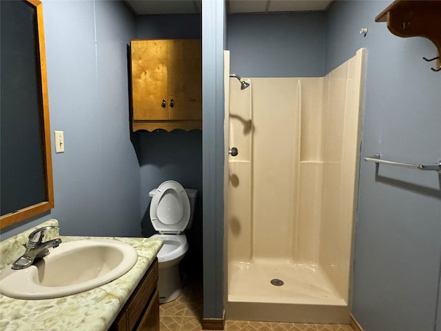 bathroom featuring tile patterned flooring, a shower, vanity, and toilet