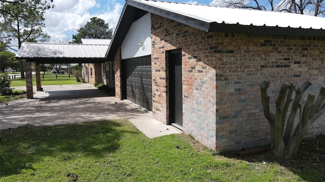 view of side of home featuring a carport, a garage, and a lawn